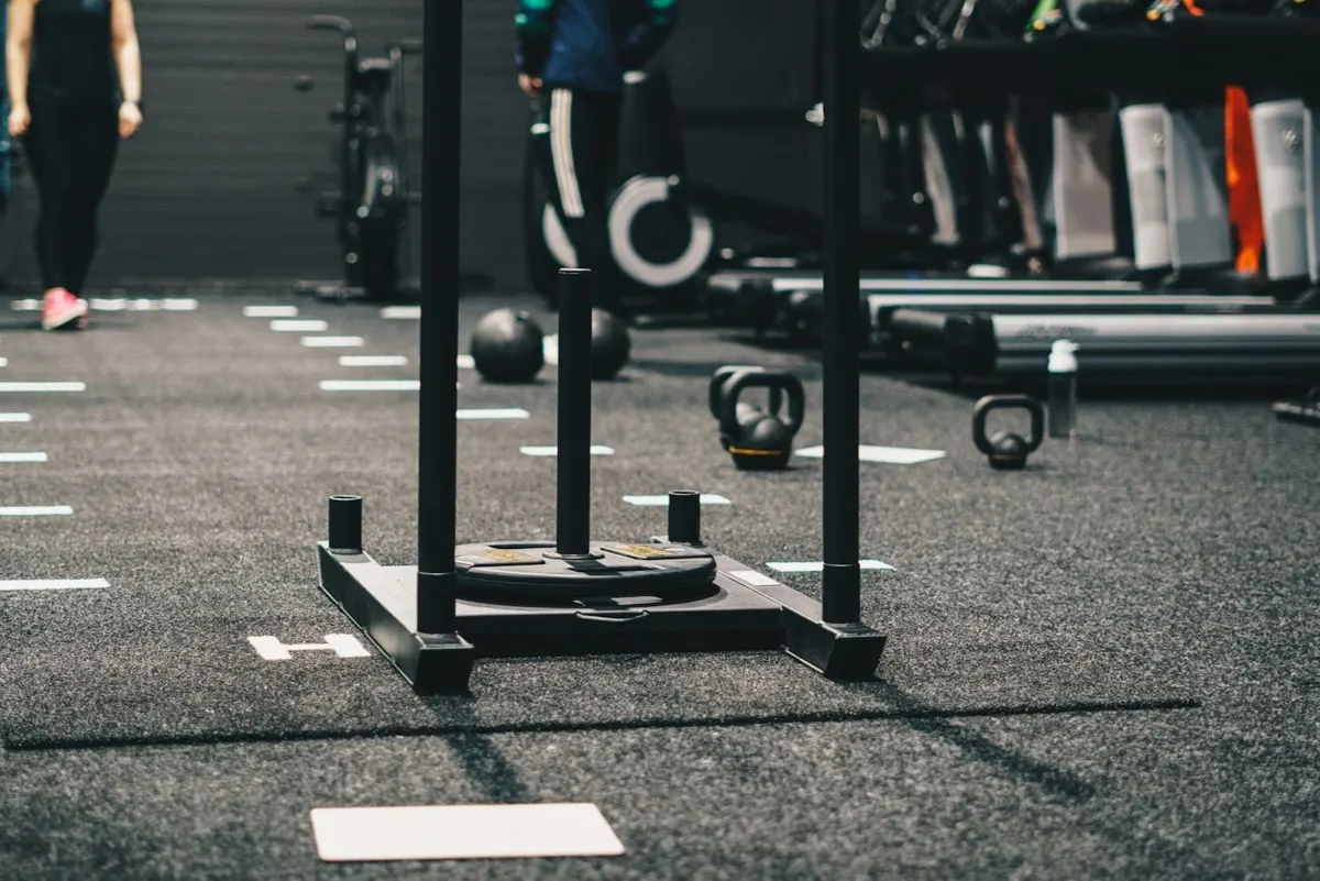 Athlete pushing a weighted sled during a functional fitness competition