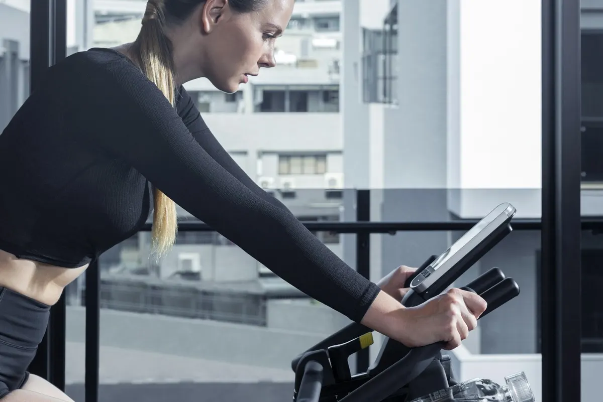 Woman training hard on a stationary bike indoors