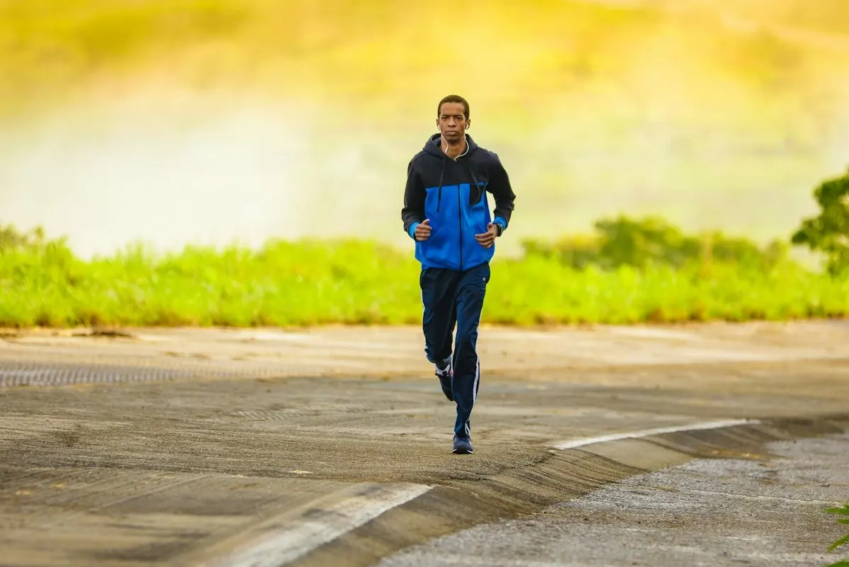 A runner pacing a hard interval on a road at golden hour