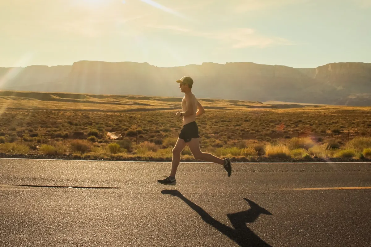 Athlete running on an open road during a sustained Norwegian 4x4 work interval