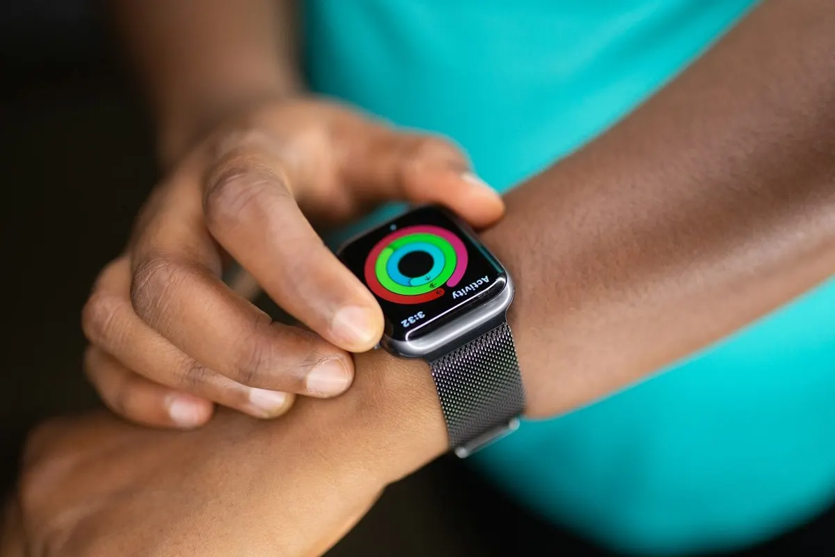Athlete checking an interval training app on a phone and Apple Watch