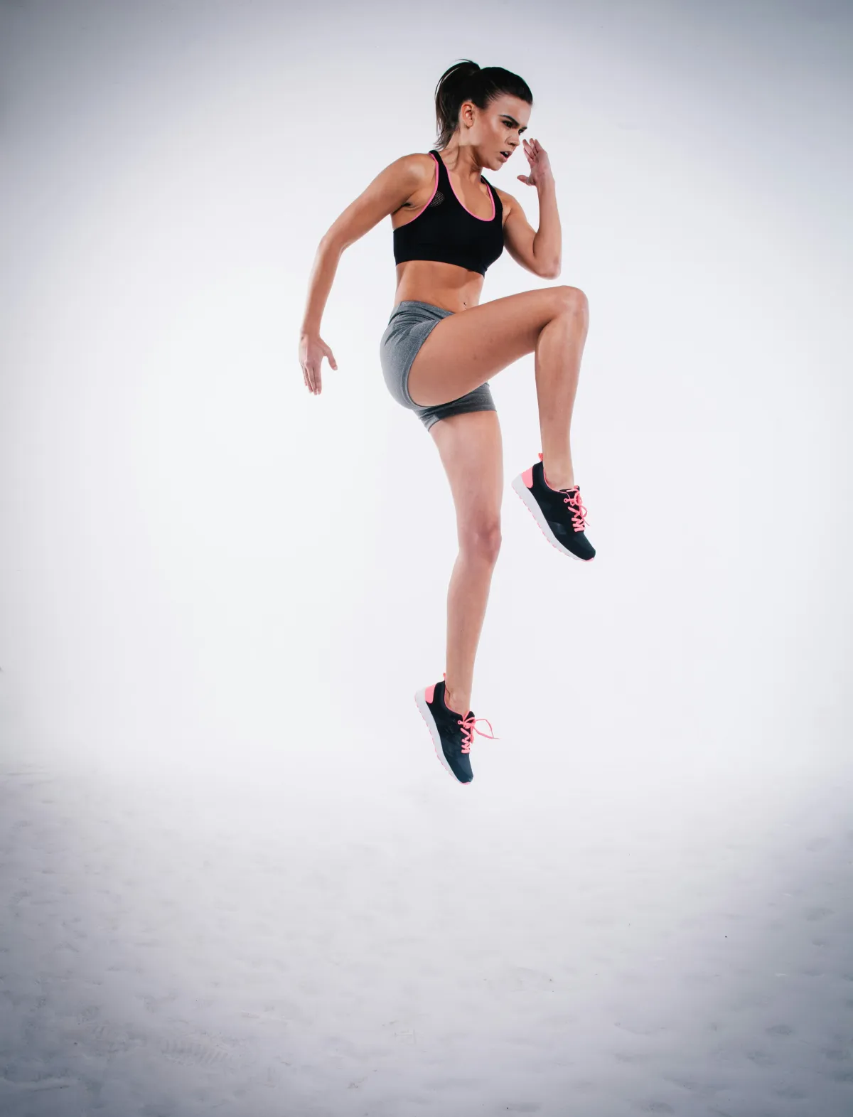 Athlete performing an explosive high-knee jump during a workout