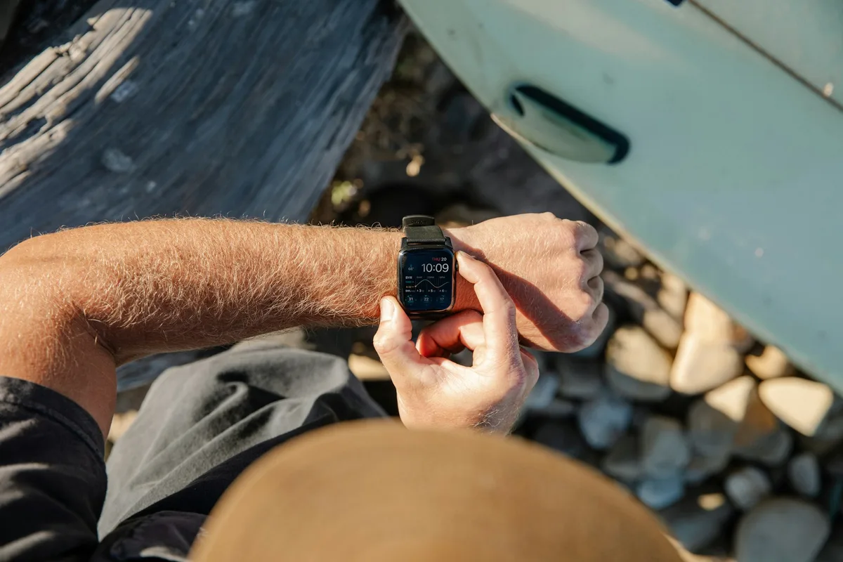 Man checking the fitness data on his Apple Watch outdoors