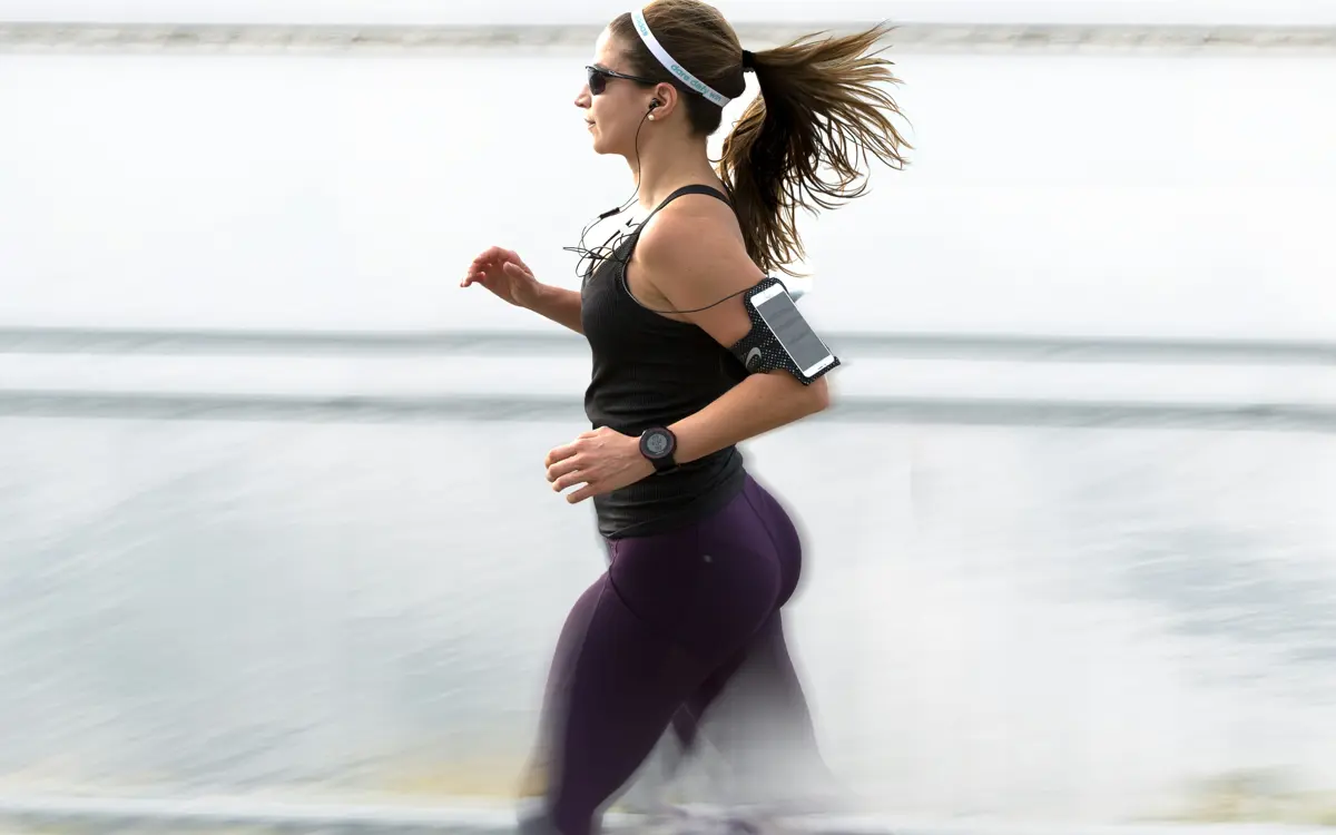 Woman running along a waterfront with motion blur
